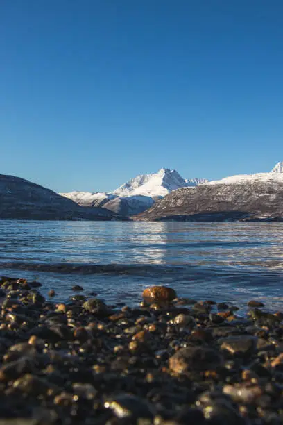 Breathtaking wildlife of the northernmost part of Norway, Finnmark. Snow-capped hills along with Balsfjorden Bay. The Scandinavian landscape. Discovering the polar region. Tromso region.