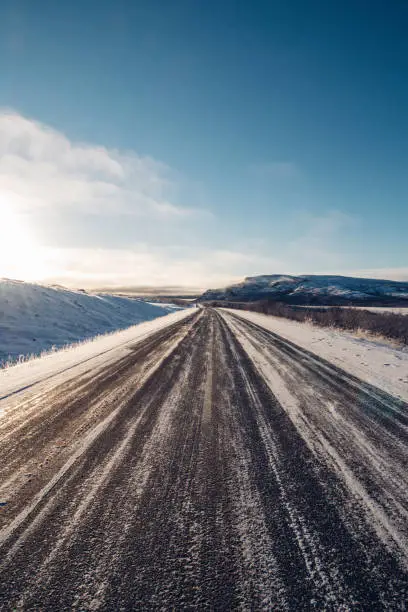 The road to nowhere. Wildlife in the Finnmark region of northern Norway on the border with Finland. Rough, inhospitable nature in winter with sunrise and blue skies. Exploring the polar region.