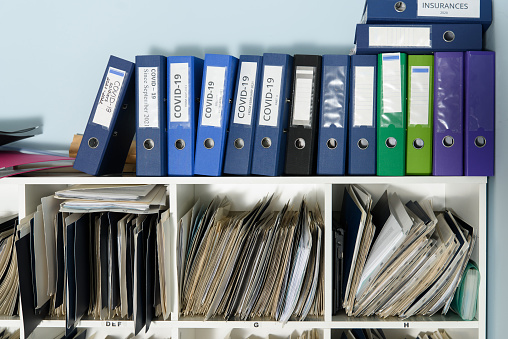 Shelves are full with folders and files of medical record, patient information.