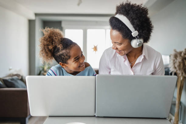 istock Mother and daughter using their laptops at home 1362947898