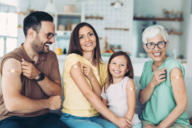 Family vaccination Portrait of a family with a child with adhesive bandages after covid-19 vaccination booster dose photos stock pictures, royalty-free photos & images