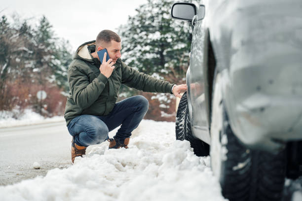 Man with broken car on the road calling roadside assistance
