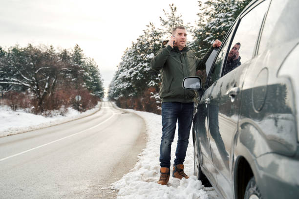 istock Man with broken car on the road calling roadside assistance 1362952251