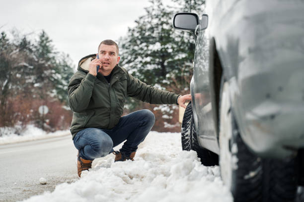 istock Man with broken car on the road calling roadside assistance 1362952252