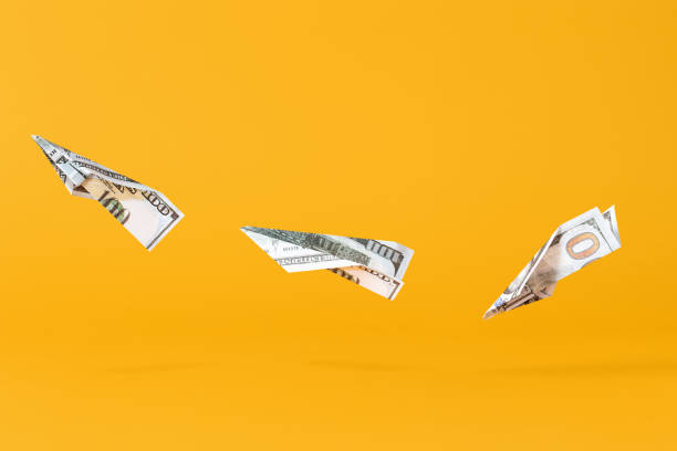 istock Three airplanes making of dollar money flying on yellow background 1362953522
