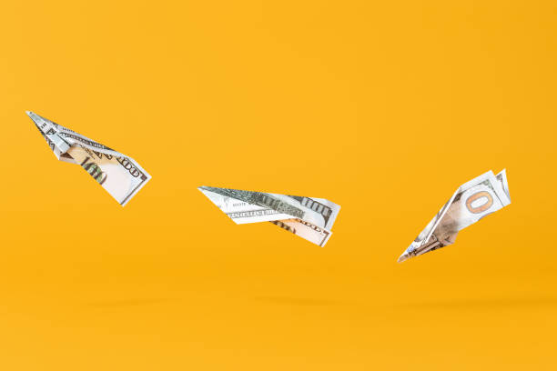 Three airplanes making of dollar money flying on yellow background Three airplanes making of dollar money flying on yellow background making money origami stock pictures, royalty-free photos & images