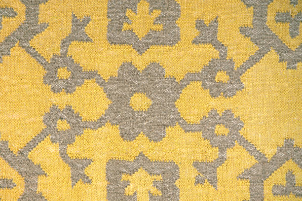 Close-up of yellow textile with abstract ethnic pattern. Boho style folk fabric.