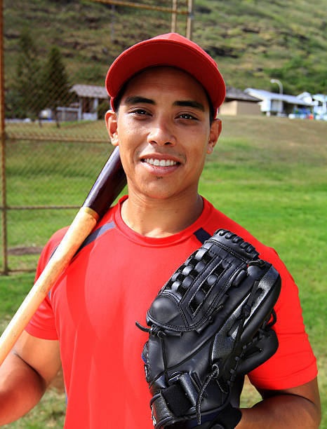 istock Baseball player smiles with his glove and bat 136295385