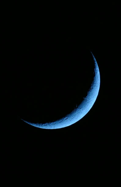 Crescent moon over mountains during the night in Norway, Lofoten.