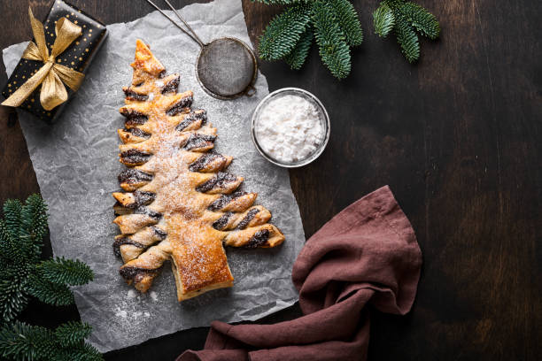 istock Puff pastry Christmas tree with chocolate paste, sprinkled with powdered sugar on old dark wooden background. Christmas or Xmas pastries. Top view. Copy Space 1362958521