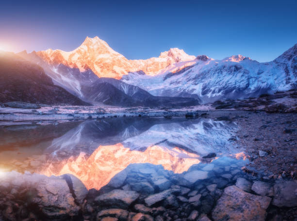 istock Snowy mountain with illuminated peaks and beautiful lake 1362960311