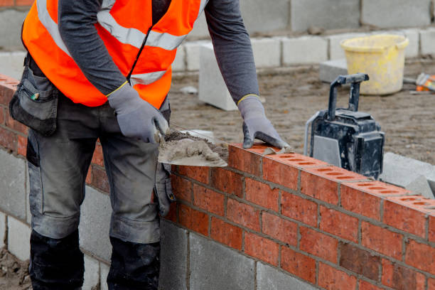 pedreiro coloca tijolos em argamassa em construção de nova casa residencial - brick construction construction site bricklayer - fotografias e filmes do acervo