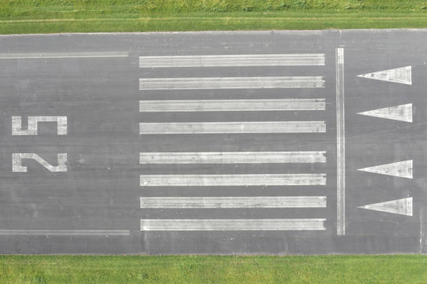 Aerial view of an airport runway with the direction marking 25 (250 degrees).