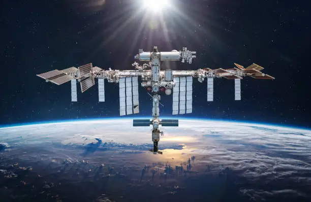 Photo of International space station in 2022 in outer space. ISS floating on orbit of Earth planet. Space sci-fi collage with satellite and spaceship. Astronauts on orbit. Elements of this image furnished by NASA