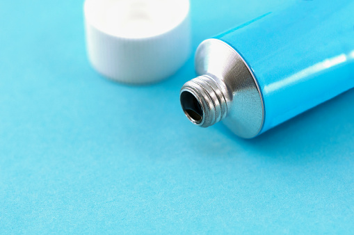 tube of ointment on a blue background close up