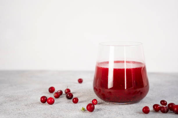 ホアフロストで覆われた冷凍ベリーと自家製の健康的なクランベリージュースのグラス。冷凍ベリーはビタミンを保存します - berry juice ストックフォトと画像