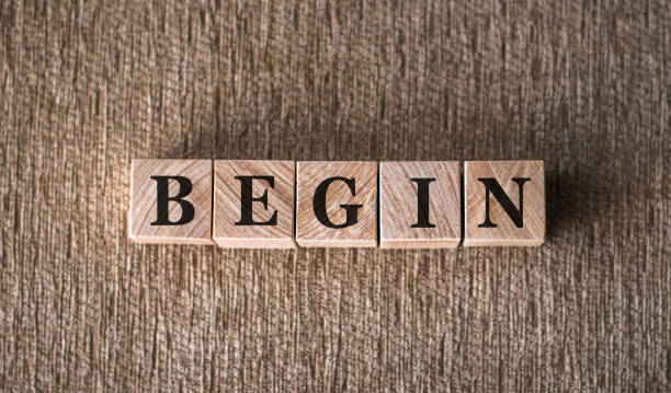 istock BEGIN word written on wooden blocks on a brown background. 1362969912