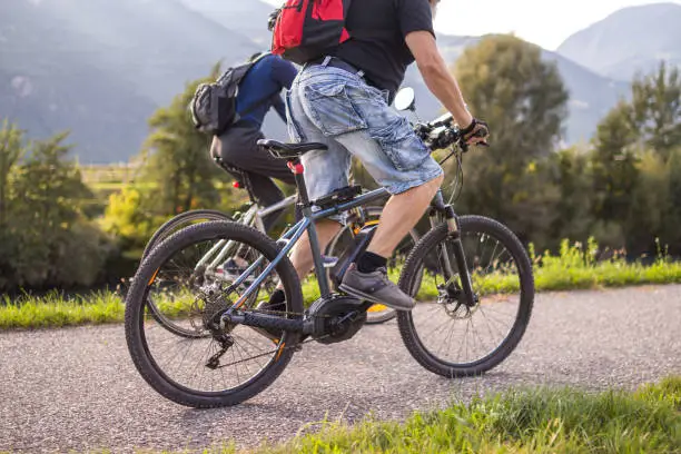 Father and son riding ebike and mountainbike on bikeway in Terlan, Southtyrol Italy; healthy active lifestyle concept