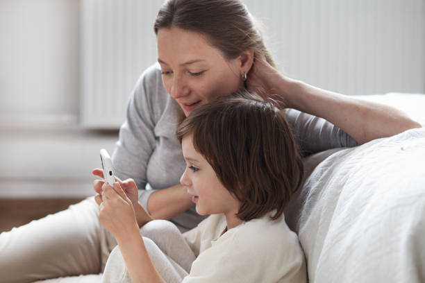 istock Confident mother learning little son use smartphone surfing internet helpful application and call 1362973984