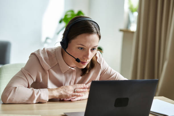 istock Concentrated young woman teacher using laptop and webcam to distant learning. 1362974086