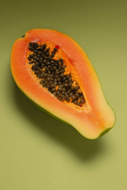 istock Papaya fruit on a green background. Half papaya. 1362977415