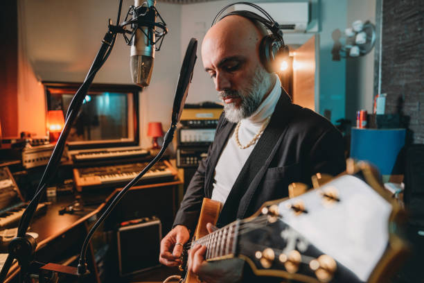 istock Musician plays guitar and sings in a recording studio 1362977626