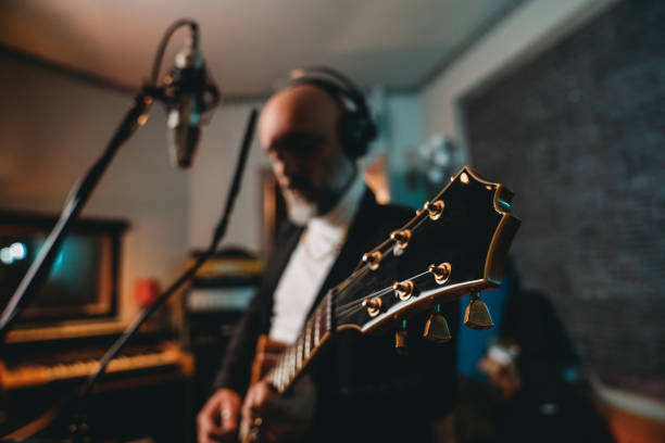 istock Musician plays guitar and sings in a recording studio 1362977628