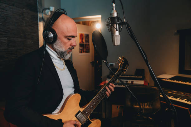 istock Musician plays guitar and sings in a recording studio 1362977632