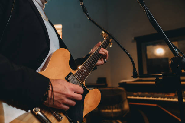istock Musician plays guitar and sings in a recording studio 1362977637