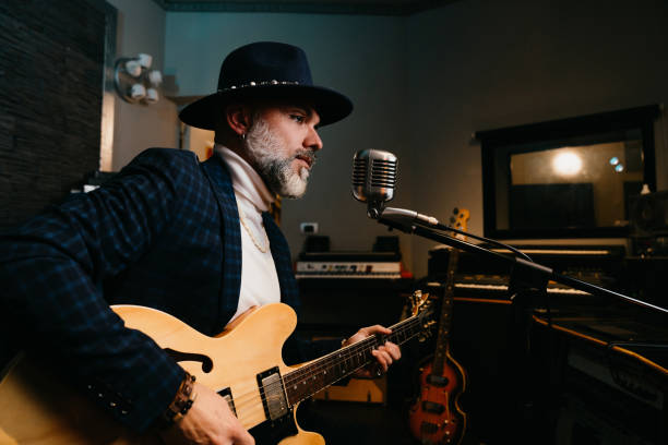 istock A musician is playing guitar and singing in a professional recording studio 1362977654