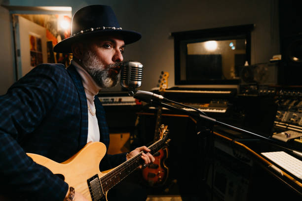 istock A musician is playing guitar and singing in a professional recording studio 1362977656