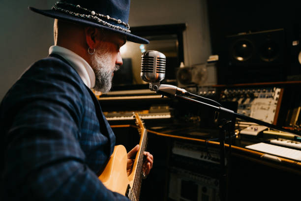 istock A musician is playing guitar and singing in a professional recording studio 1362977658