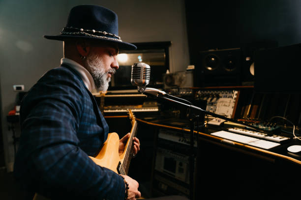 istock A musician is playing guitar and singing in a professional recording studio 1362977659
