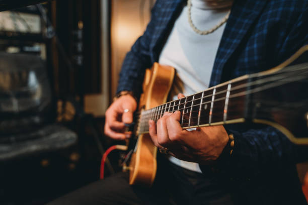 particolare delle mani di un musicista che suona una chitarra - guitar music guitarist recording studio foto e immagini stock