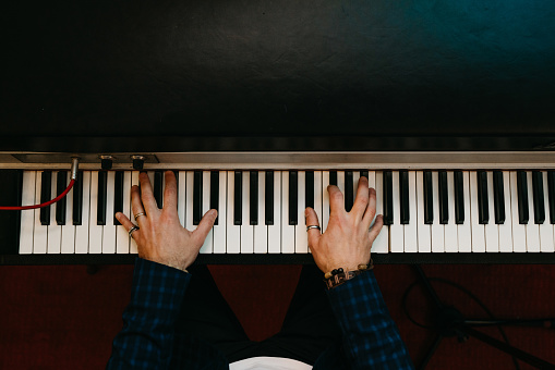 Pov view of a man playing piano. He's playing a vintage piano.