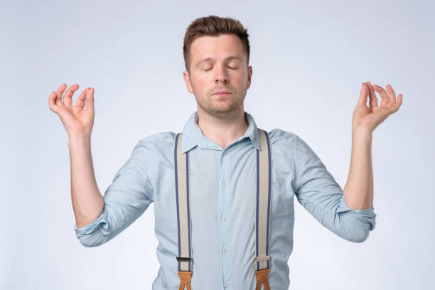 istock Young caucasian man with peaceful expression meditating, holding his hands in mudra gesture 1362977834