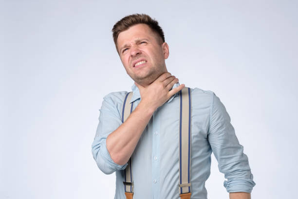 istock Young man with throat pain isolated on white background 1362977914