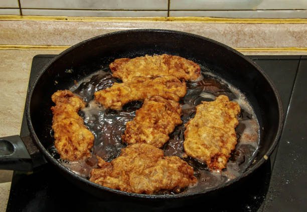 istock Beef chops in a pan on the stove. The process of preparing beef chops in batter 1362977989