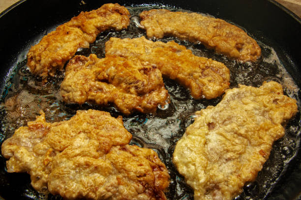 istock Beef chops in a pan on the stove. The process of preparing beef chops in batter 1362978015