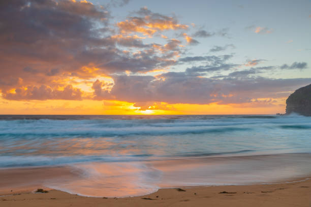 istock Sunrise at the seaside with waves and clouds 1362979792