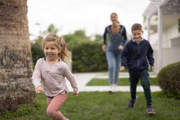 istock Mother playing in back yard with her two kids 1362980444