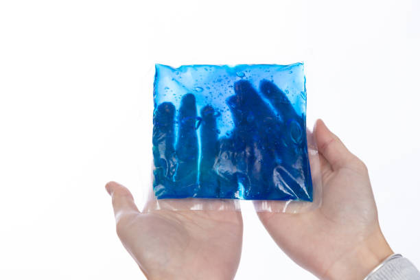 blue color cold gel packet in hand blue color cold gel packet in hand ice pack photos stock pictures, royalty-free photos & images