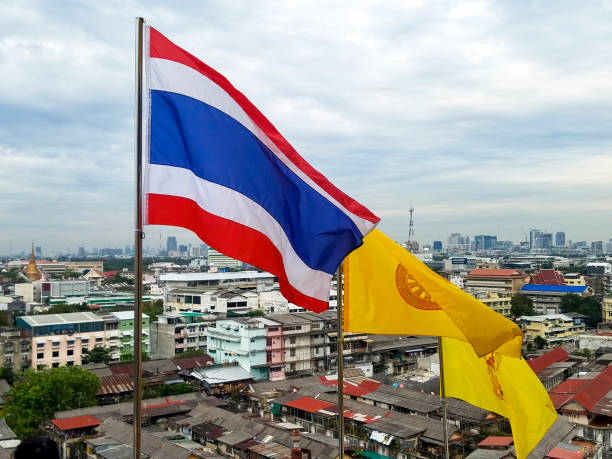Thailand Flags Viewed from The Golden Mountain Temple. Bangkok, Thailand - January 3, 2019: Three flags flown at The Golden Mountain Temple (Wat Saket) overlooking Bangkok including the Flag of Thailand, the Buddhist Dharmacakra flag and the personal flag of King Vajiralongkorn. thai flag stock pictures, royalty-free photos & images