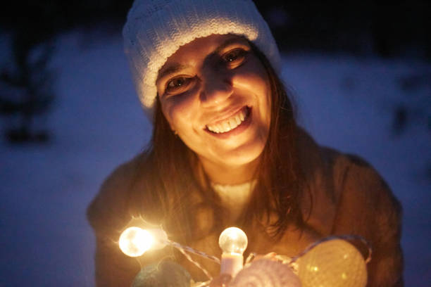 christmas lights girl looking at camera in snow