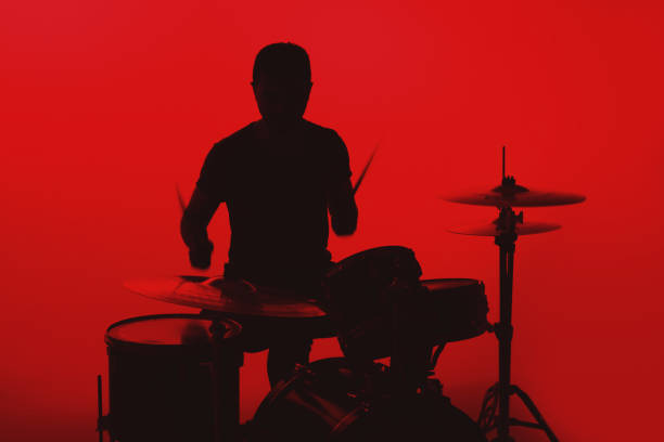 istock Silhouette of a young man playing drums on a red background 1362993329