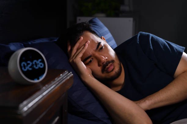 istock Depressed young Asian man lying in bed cannot sleep from insomnia 1362993331