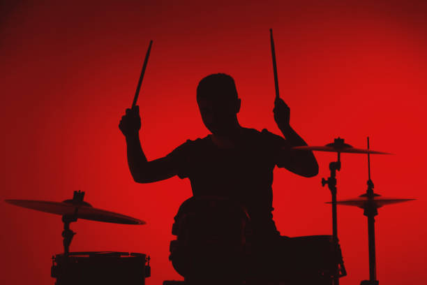 istock Silhouette of a young man playing drums on a red background 1362993333