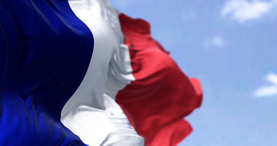 Detail of the national flag of France waving in the wind on a clear day. Democracy and politics. European country.