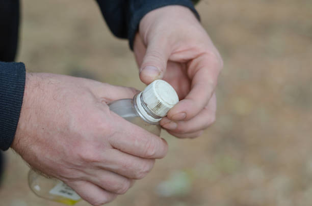 istock Two hands of a grown man holding a plastic bottle. Liquid fire s 1362996970