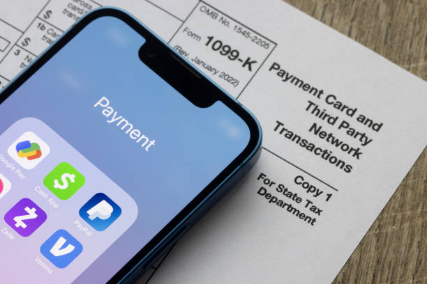 Third-Party Payment Apps Portland, OR, USA - Jan 5, 2022: Payment apps like PayPal and Venmo are seen on an iPhone on top of Form 1099-k. Third-party payment apps now have to report transactions more than USD600 to the IRS. paypal stock pictures, royalty-free photos & images